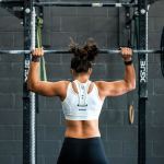 Mujer entrenando en un rack de potencia